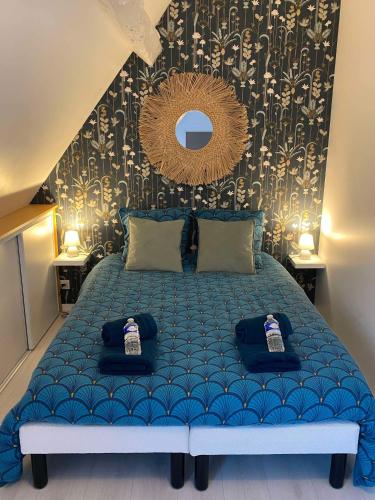 - une chambre avec un lit bleu et un miroir mural dans l'établissement QUAI 65 , 3 pièces sur le port, à 250 m de la rue piétonne et de la mer, à Dieppe