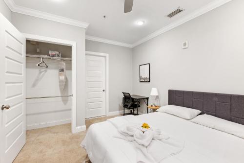 a white bedroom with a white bed and a chair at Lavish 1BR with Pool & Gym Access in Philadelphia