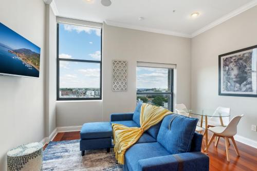 a living room with a blue couch and a table at Lavish 1BR with Pool & Gym Access in Philadelphia