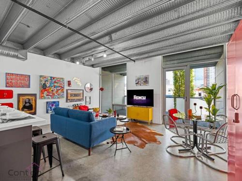 a living room with a blue couch and a table at Urban Pop Loft, Near ICE District, UG Parking in Edmonton