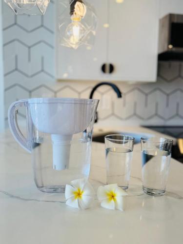 a blender on a counter with two glasses of water at Panoramic Oceanview Resort - Full Kitchen in Each Unit, 2 Swimming Pools, Onsite Restaurants, Fireworks Every Friday in Honolulu