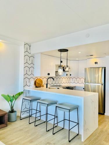 a kitchen with a blue counter and stools at Panoramic Oceanview Resort - Full Kitchen in Each Unit, 2 Swimming Pools, Onsite Restaurants, Fireworks Every Friday in Honolulu