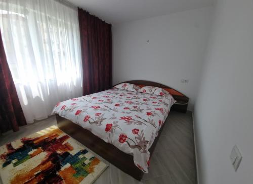 a small bedroom with a bed with a floral bedspread at Cavnic Residence 1 in Cavnic