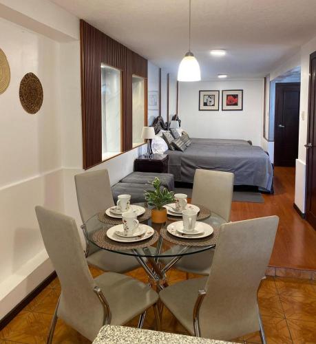 a living room with a table and chairs and a bed at Hospedaje en Quito Norte, Apartamento & Suite independientes in Quito