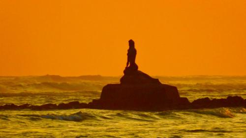 a woman standing on a rock in the ocean at Casa Vista Pacifico in Esterillos