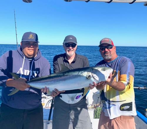 a group of three men holding a fish on a boat at Hotel Luna Loreto in Loreto