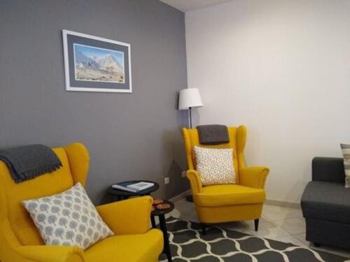 - un salon avec deux chaises jaunes et un canapé dans l'établissement Maison de Bergers, Cyclist & Ski Friendly Town House, WIFI, Secure Bike Store, au Bourg-dʼOisans