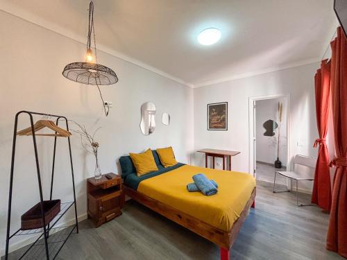 a bedroom with a bed with yellow sheets and yellow pillows at Aquarela do Tejo Guesthouse in Vila Franca de Xira