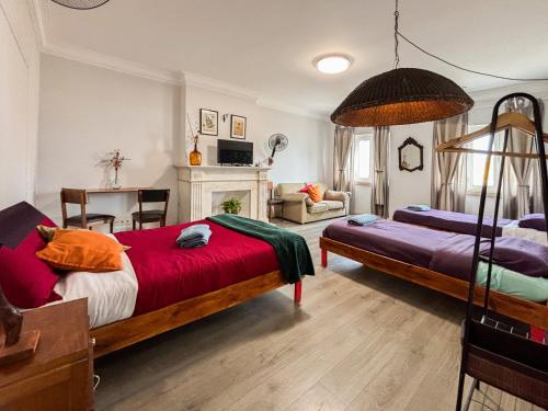 a bedroom with two beds and a fireplace at Aquarela do Tejo Guesthouse in Vila Franca de Xira