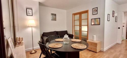 un salon avec une table et un canapé dans l'établissement Home Sweet Home Champs Elysées Berri, à Paris