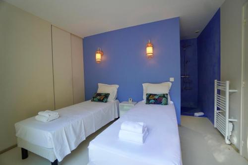 zwei Betten in einem Zimmer mit einer blauen Wand in der Unterkunft Villa U Principellu in Saint-Florent
