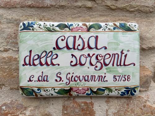 Montefiore dellʼAsoにあるCasa delle Sorgentiの石垣の脇にある標識