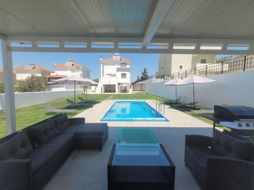a patio with a couch and a swimming pool at Villa Maritsá in Pastida