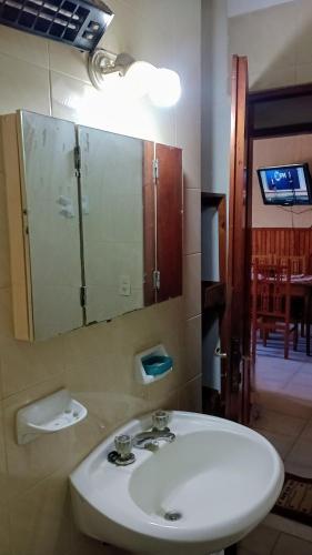 een badkamer met een witte wastafel en een spiegel bij Nono110 in Villa Gesell