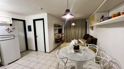 eine Küche und ein Esszimmer mit einem Tisch und einem Kühlschrank in der Unterkunft Muro Alto -Flat - Porto de Galinhas Beira mar in Porto De Galinhas