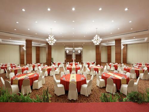 a banquet hall with red and white tables and chairs at Aryaduta Manado in Manado