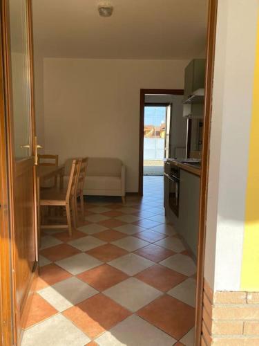 a kitchen with a tiled floor with a table and a couch at La Sosta Vercellese in Borgo Vercelli