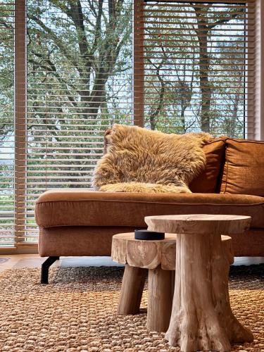 a living room with a couch and a table at Wellness Chalet Hellendoorn met Hot tub en Sauna in Haarle