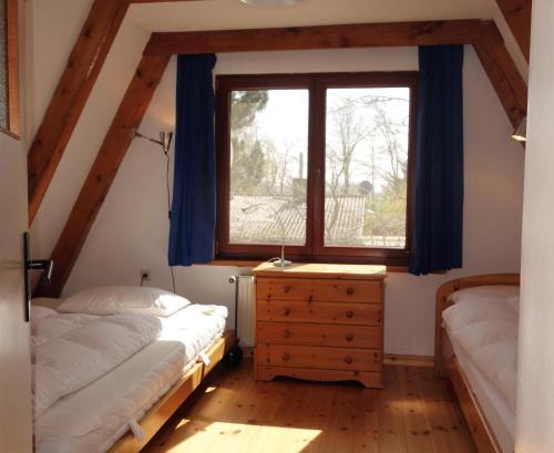 阿伦斯霍普Ferienhaus-Fischlandde Grünbaum Ahrenshoop的有两张床和一扇窗户的卧室