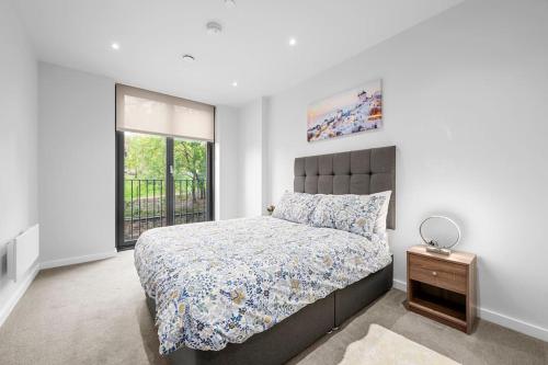a bedroom with a large bed and a window at Manchester Haven Luxurious Apartment in Manchester