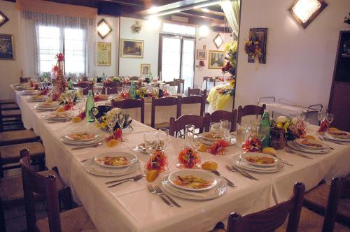 リッツァーノ・イン・ベルヴェデーレにあるHotel Brunaの長いテーブルに盛り付けられたお皿