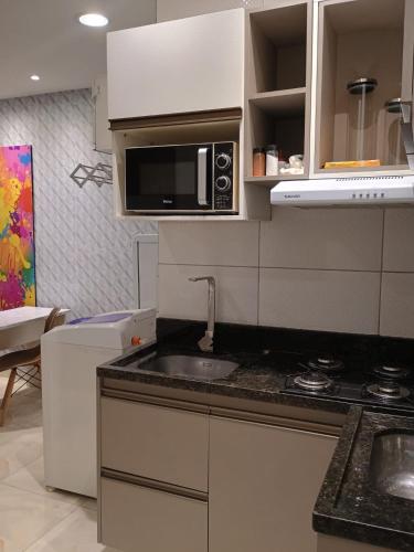 a kitchen with a sink and a microwave at Apto Pelourinho Centro Histórico in Salvador
