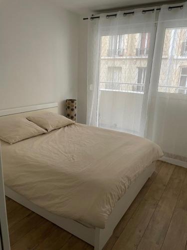 une chambre blanche avec un lit et une fenêtre dans l'établissement Cozy appartement Clichy, very good location, à Clichy