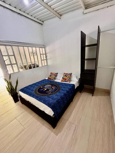 a bedroom with a large bed with a blue blanket at Hostel no glam boutique in Nocaima
