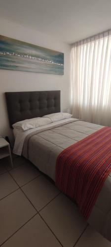 a large bed in a bedroom with a window at Sumaq AirPort in Lima