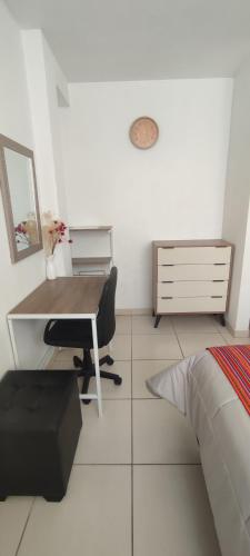 a bedroom with a desk and a bed at Sumaq AirPort in Lima