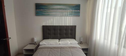 a bedroom with a bed and a painting on the wall at Sumaq AirPort in Lima