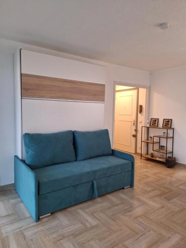 - un canapé bleu dans le salon dans l'établissement Malyna, à Mandelieu-la-Napoule