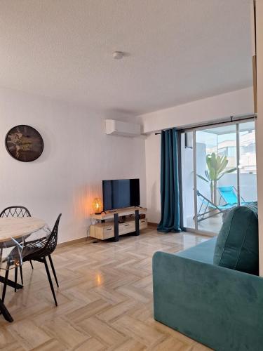 un salon avec un canapé, une télévision et une table dans l'établissement Malyna, à Mandelieu-la-Napoule