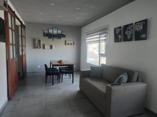 un salon avec un canapé et une table dans l'établissement Balatis Apartamento Ushuaia, à Ushuaia