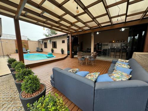 a patio with a couch and a swimming pool at Tanuri in Itapoa