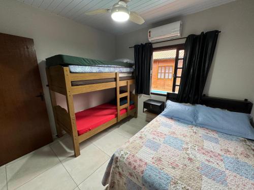 a bedroom with two bunk beds and a window at Tanuri in Itapoa