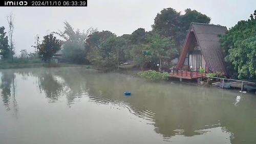 a large lake with a building on the side of it at Banromsak resort - บ้านร่มสักรีสอร์ต in Ban Dok Kham Tai (1)