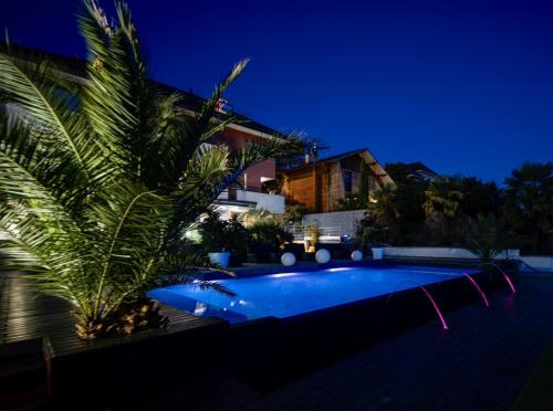 a swimming pool in front of a house at night at Les Suites du Lac in Aix-les-Bains