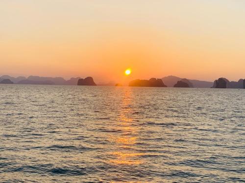 a sunset over the water with islands in the background at Yada Resort Koh Yao Noi in Ko Yao Noi