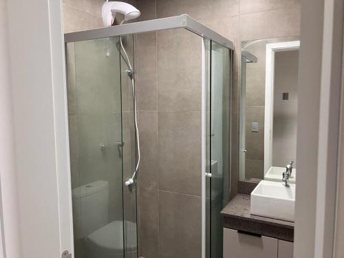 a bathroom with a glass shower and a sink at Loft Livin Resort 411 T3 Piscina Térmica Atlantida Xangri-la in Xangri-lá