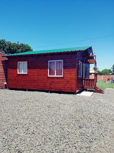 Cabaña roja pequeña con techo verde en Cabaña Las Martinetas, en María Grande