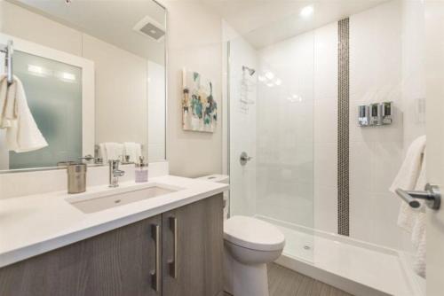 a bathroom with a sink and a toilet and a shower at Modern Old Town Suite With Private Balcony in Victoria