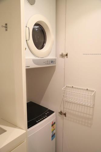 a small kitchen with a microwave and a refrigerator at Seabreezes South Fremantle in South Fremantle