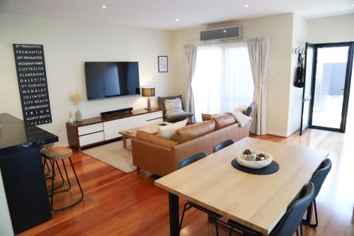 a living room with a table and a couch at Seabreezes South Fremantle in South Fremantle