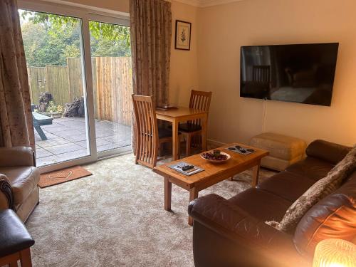 a living room with a couch and a table at Chestnut Lodge Annex in Bridgend