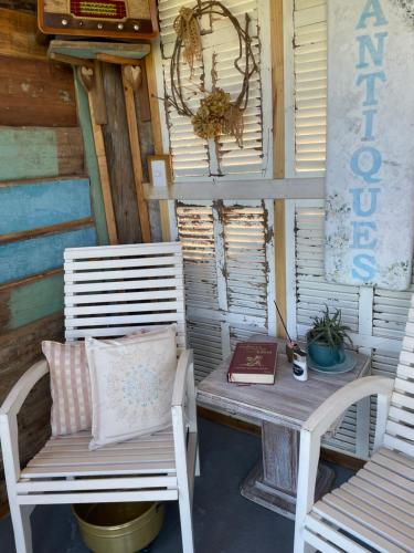two chairs and a table with a book on a porch at Chalé Terra Luni in Urubici
