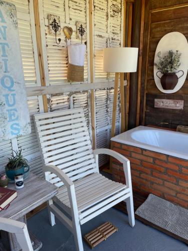 a white rocking chair sitting next to a bath tub at Chalé Terra Luni in Urubici