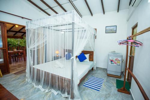 a bedroom with a bed with a net at Turtle Lamp in Unawatuna