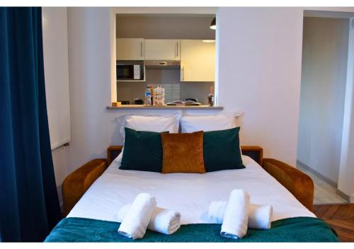 a bedroom with a bed with towels on it at Le Charme D'Antan - Terrasse - Balcon - Hypercentre Evreux in Évreux