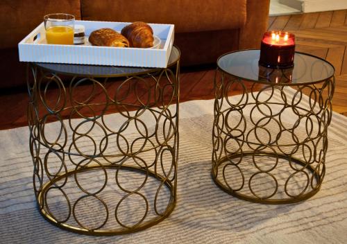 two tables with a tray of donuts and a candle at Le Charme D'Antan - Terrasse - Balcon - Hypercentre Evreux in Évreux